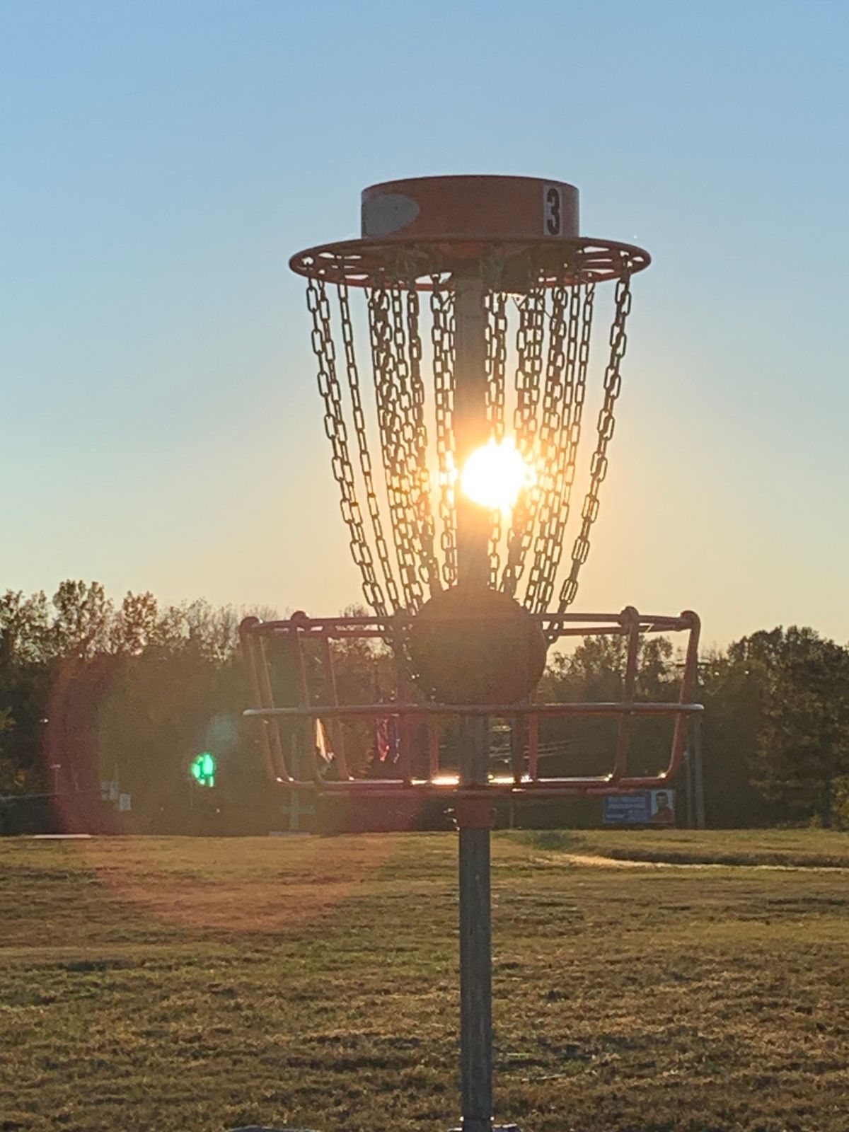 Sun setting behind Hole 3 basket.