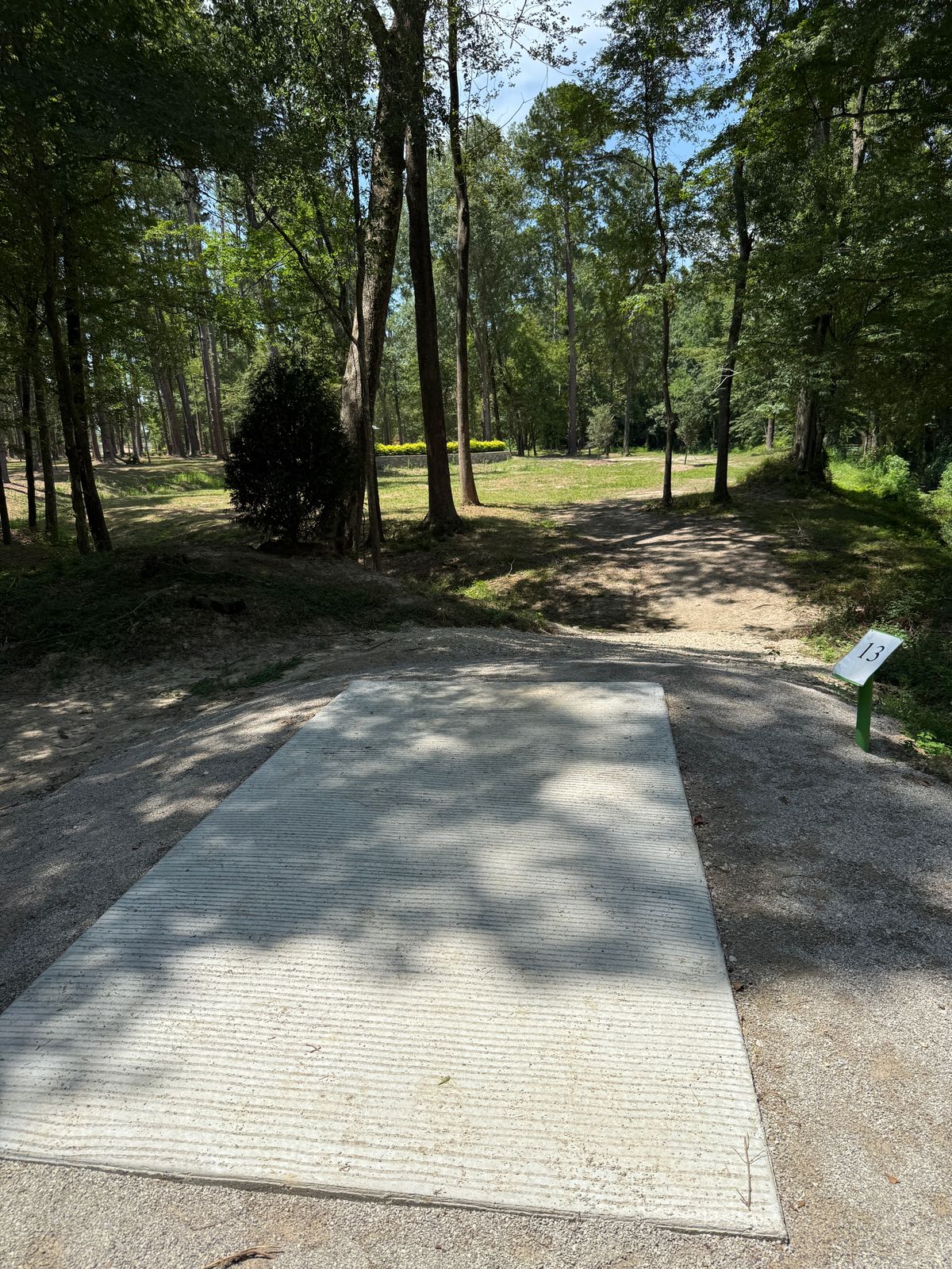 Tee of 13 (basket on top of raised retainer wall left behind hedge bushes)