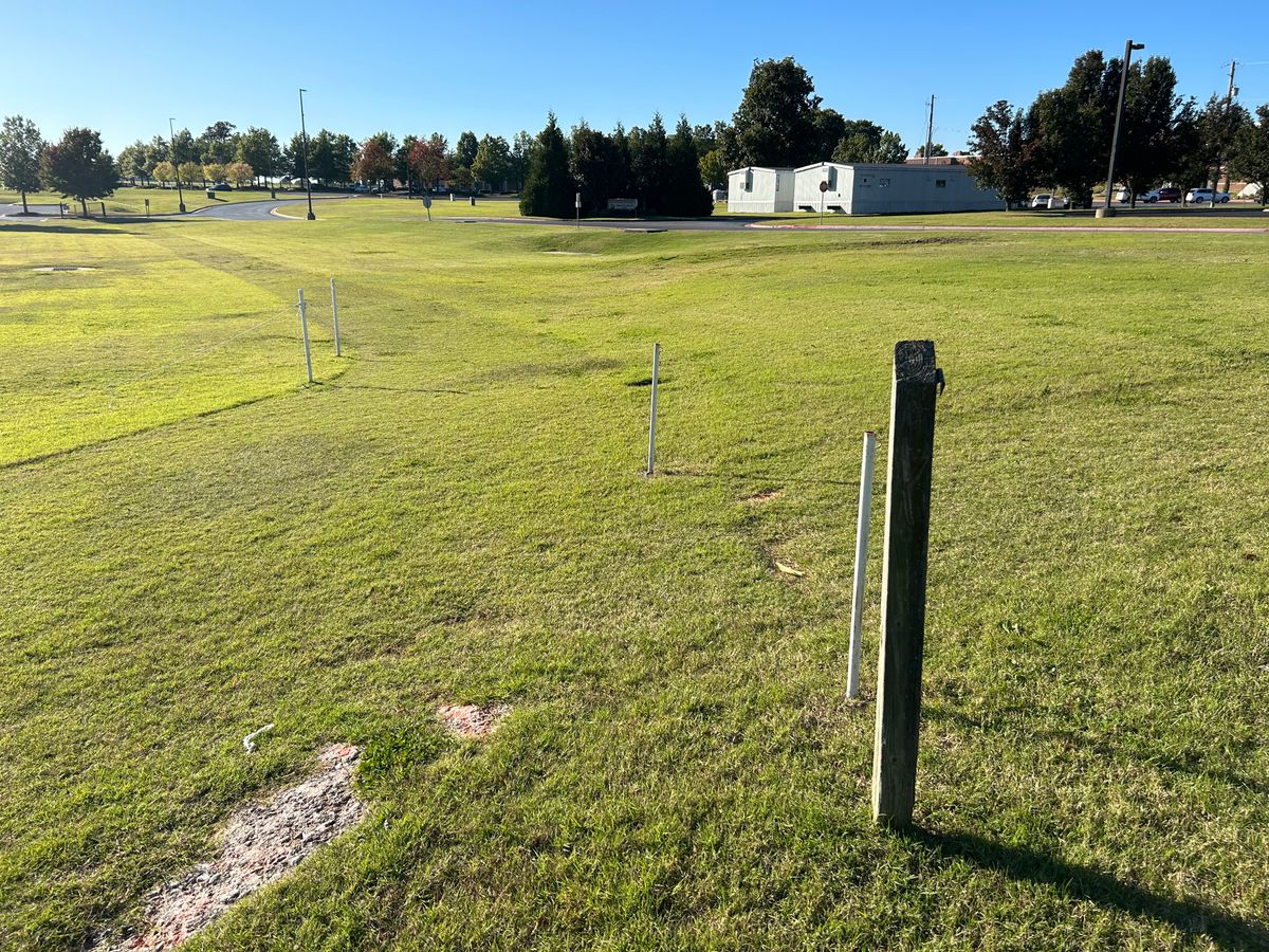 Hole #17 Grass Tee Pad. Please be careful when throwing over roads. Look for cars and watch out for the temporary buildings. Throw to the left of the evergreens. 